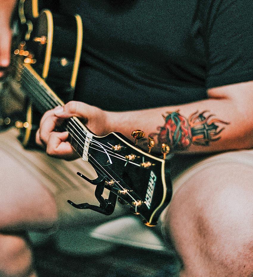 Man with Tattoo on Arm Playing Guitar Man with Tattoo on Arm Playing Guitar